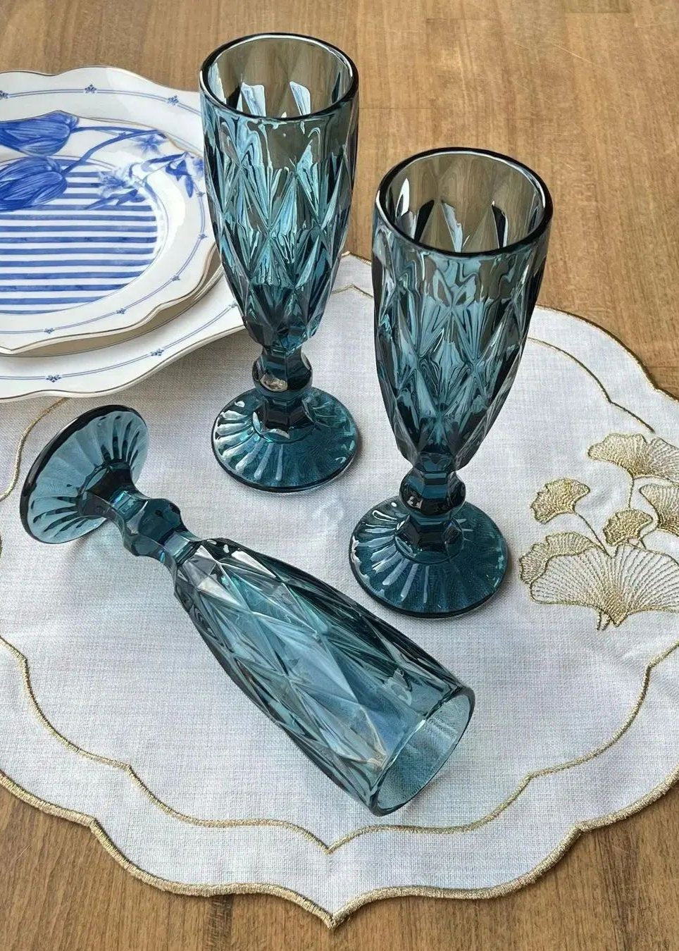 Blue cut-glass flutes on a placemat.