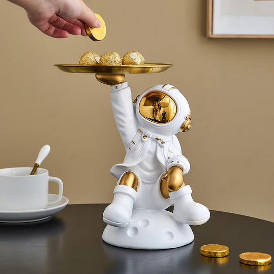 Decorative astronaut figurine holding a metal tray, ideal for space-themed home decor

