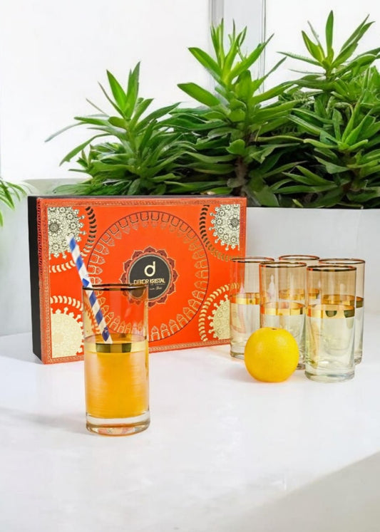Six tall green glasses with elegant gold rims