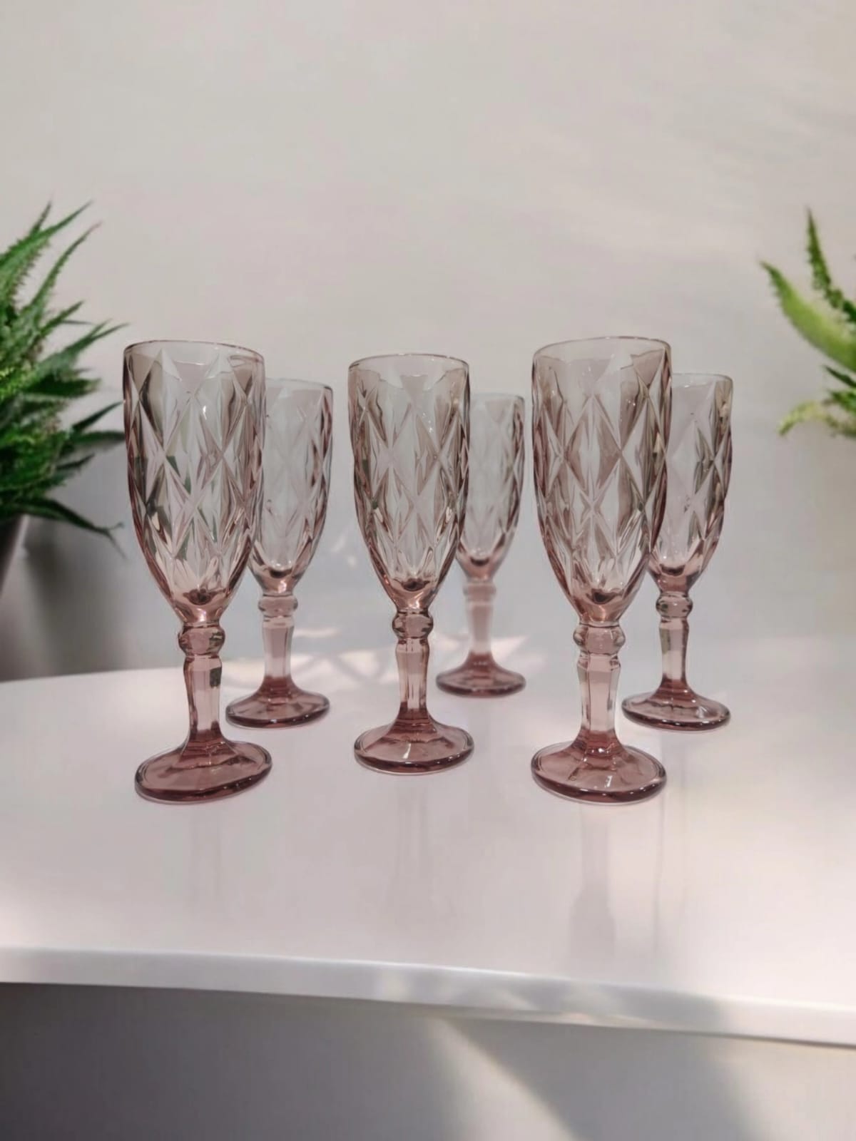 Textured pink glasses arranged on a table