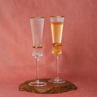 Tall crystal glasses with vertical grooves and gold accents